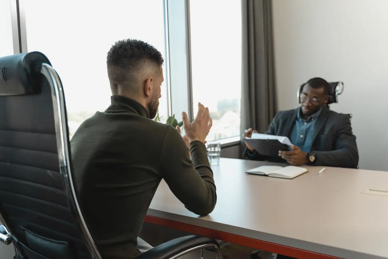 Entrevista de trabajo entre una responsable de personal y un candidato en una oficina